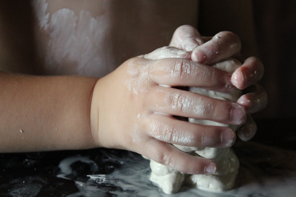 toddler being creative with clay and playdough